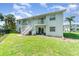 Two-story building showcasing the stairs leading up to the balconies and patios with lawn at 522 Pine Ave # 8B, Anna Maria, FL 34216