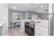 Contemporary kitchen featuring stainless steel appliances, marble countertops, and a view into the dining and living areas at 522 Pine Ave # 8B, Anna Maria, FL 34216