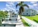 Beautiful waterfront view with docks, canal and palm trees alongside the condo building on a sunny day at 522 Pine Ave # 8B, Anna Maria, FL 34216