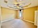 Bedroom with tray ceiling, fan, carpet floors and a window providing natural light at 5620 Whitehead St, Bradenton, FL 34203