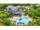 Aerial view of a stunning clubhouse with a large pool, palm trees, and well-maintained landscaping at 5927 Maidenstone Way, Palmetto, FL 34221