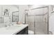 Updated bathroom features a quartz countertop, dark vanity, and sliding glass shower doors at 5927 Maidenstone Way, Palmetto, FL 34221