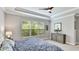 Relaxing bedroom features a decorative tray ceiling, neutral walls, and a large window at 5927 Maidenstone Way, Palmetto, FL 34221