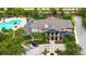 Aerial view of a community pool surrounded by lush landscaping, sun loungers, and a modern clubhouse at 5927 Maidenstone Way, Palmetto, FL 34221