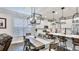 Open kitchen and dining area featuring a long wooden table underneath decorative light fixtures at 5927 Maidenstone Way, Palmetto, FL 34221