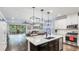 Open-concept kitchen and living room featuring a large island with modern pendant lighting at 5927 Maidenstone Way, Palmetto, FL 34221