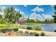 Scenic view of a pond with a stone bridge, lush landscaping, and vibrant flowers on a sunny day at 5927 Maidenstone Way, Palmetto, FL 34221