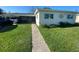 Charming single-story home with a well-manicured lawn and a covered front patio at 6048 Merril St, North Port, FL 34287