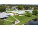 Aerial view of a yellow home with a light green roof, fenced yard, and a pond at 6114 68Th E Dr, Palmetto, FL 34221