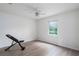 Bright bedroom with neutral walls, wood-look floors, a ceiling fan, and a window overlooking a green space at 6114 68Th E Dr, Palmetto, FL 34221