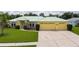 Inviting home with a well-manicured lawn, driveway, and a light green roof at 6114 68Th E Dr, Palmetto, FL 34221