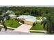 An aerial view of the home's front exterior, landscaping, and the scenic pond, emphasizing the property's setting at 6114 68Th E Dr, Palmetto, FL 34221
