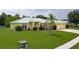 A charming yellow home with a well-manicured lawn and front garden, showcasing its curb appeal at 6114 68Th E Dr, Palmetto, FL 34221