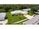 Aerial front view of yellow house, green roof, and landscaped lawn, highlighting curb appeal and neighborhood setting at 6114 68Th E Dr, Palmetto, FL 34221