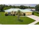 Inviting yellow home with a green metal roof, well-manicured lawn, and a spacious driveway at 6114 68Th E Dr, Palmetto, FL 34221