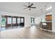 Spacious living area with hardwood floors, fan, access to an enclosed porch, and kitchen at 6114 68Th E Dr, Palmetto, FL 34221