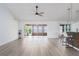 Open-concept living area with hardwood floors, fan, and access to the enclosed porch at 6114 68Th E Dr, Palmetto, FL 34221