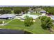 Aerial view of a home showcasing its backyard, green roof, and proximity to a serene pond at 6114 68Th E Dr, Palmetto, FL 34221