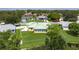 Aerial view of a home with a well-kept lawn, green roof, and patio area surrounded by lush landscaping at 6114 68Th E Dr, Palmetto, FL 34221