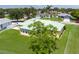 Aerial view of the home's backyard, green roof, lush trees, and well-maintained lawn at 6114 68Th E Dr, Palmetto, FL 34221