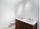 Modern bathroom features double sinks with a wood vanity and a toilet at 6341 Cocoa Ln, Apollo Beach, FL 33572