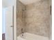 Modern bathroom featuring a tub with shower and tan tiling at 6341 Cocoa Ln, Apollo Beach, FL 33572