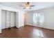 Bedroom featuring wood-look flooring, a ceiling fan, closet with built in shelving, and a window at 6341 Cocoa Ln, Apollo Beach, FL 33572