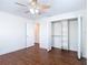Bedroom featuring wood-look flooring, a ceiling fan, closet with built in shelving, and a door at 6341 Cocoa Ln, Apollo Beach, FL 33572