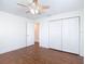 Bedroom featuring wood-look flooring, a ceiling fan, closet and a door at 6341 Cocoa Ln, Apollo Beach, FL 33572