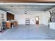 Spacious garage with a painted floor, workbench area, storage, exterior door and utilities at 6341 Cocoa Ln, Apollo Beach, FL 33572