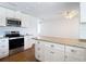 Well-lit kitchen with white cabinets, granite countertops, and stainless steel appliances at 6341 Cocoa Ln, Apollo Beach, FL 33572