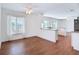 Open concept living room with wood-look floors, ceiling fan, and a kitchen island at 6341 Cocoa Ln, Apollo Beach, FL 33572