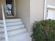Home's entrance features stairs to the front door and colorful red flowers at the base of the house at 6821 Fairview Ter # 6821, Bradenton, FL 34203