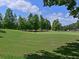 Scenic view of a lush green golf course with mature trees under a partly cloudy blue sky at 6821 Fairview Ter # 6821, Bradenton, FL 34203