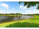 Expansive backyard with lush green lawn bordering a peaceful lake at 6854 Chester Trl, Lakewood Ranch, FL 34202