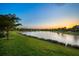 Scenic backyard view with a peaceful lake and beautiful sunset sky at 6854 Chester Trl, Lakewood Ranch, FL 34202