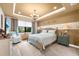 The bedroom features tray ceilings, modern lighting, decor, and a cozy sitting area by the window at 6854 Chester Trl, Lakewood Ranch, FL 34202
