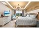 Bedroom features tray ceilings, neutral walls, modern lighting, and a comfortable sitting area by the window at 6854 Chester Trl, Lakewood Ranch, FL 34202