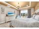 Bedroom features a tray ceiling, neutral walls, modern decor, and a window with a view of the outdoors at 6854 Chester Trl, Lakewood Ranch, FL 34202
