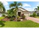 Inviting single-story home featuring lush tropical landscaping and a brick-paved driveway at 6854 Chester Trl, Lakewood Ranch, FL 34202