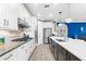 Bright kitchen features stainless appliances, an island with a marble countertop, and white cabinets with black hardware at 6854 Chester Trl, Lakewood Ranch, FL 34202