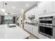 This spacious kitchen features modern stainless steel appliances, ample white cabinetry and a large marble countertop island at 6854 Chester Trl, Lakewood Ranch, FL 34202