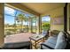 Screened-in lanai with comfortable seating, brick flooring, and a scenic view of the pond and landscaping at 6854 Chester Trl, Lakewood Ranch, FL 34202