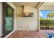 Lanai with brick flooring and an outdoor kitchen space, offering a glimpse of the backyard landscaping at 6854 Chester Trl, Lakewood Ranch, FL 34202