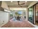 Lanai with brick flooring, ceiling fans, dining table, and a serene view of the pond and lush greenery at 6854 Chester Trl, Lakewood Ranch, FL 34202