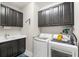 The laundry room boasts dark cabinetry, modern appliances, and a sink for added convenience at 6854 Chester Trl, Lakewood Ranch, FL 34202