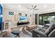 Comfortable living room area featuring a ceiling fan, sliding glass doors, and a modern entertainment center at 6854 Chester Trl, Lakewood Ranch, FL 34202