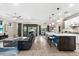 Open-concept living space features modern decor, kitchen island with stools, comfortable seating, and access to the lanai at 6854 Chester Trl, Lakewood Ranch, FL 34202