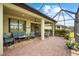Covered brick patio with comfortable seating, ceiling fans, and a picturesque outdoor dining area at 6854 Chester Trl, Lakewood Ranch, FL 34202