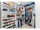 Walk-in closet featuring custom shelving for organized storage of shoes, handbags, and hanging clothes at 6854 Chester Trl, Lakewood Ranch, FL 34202